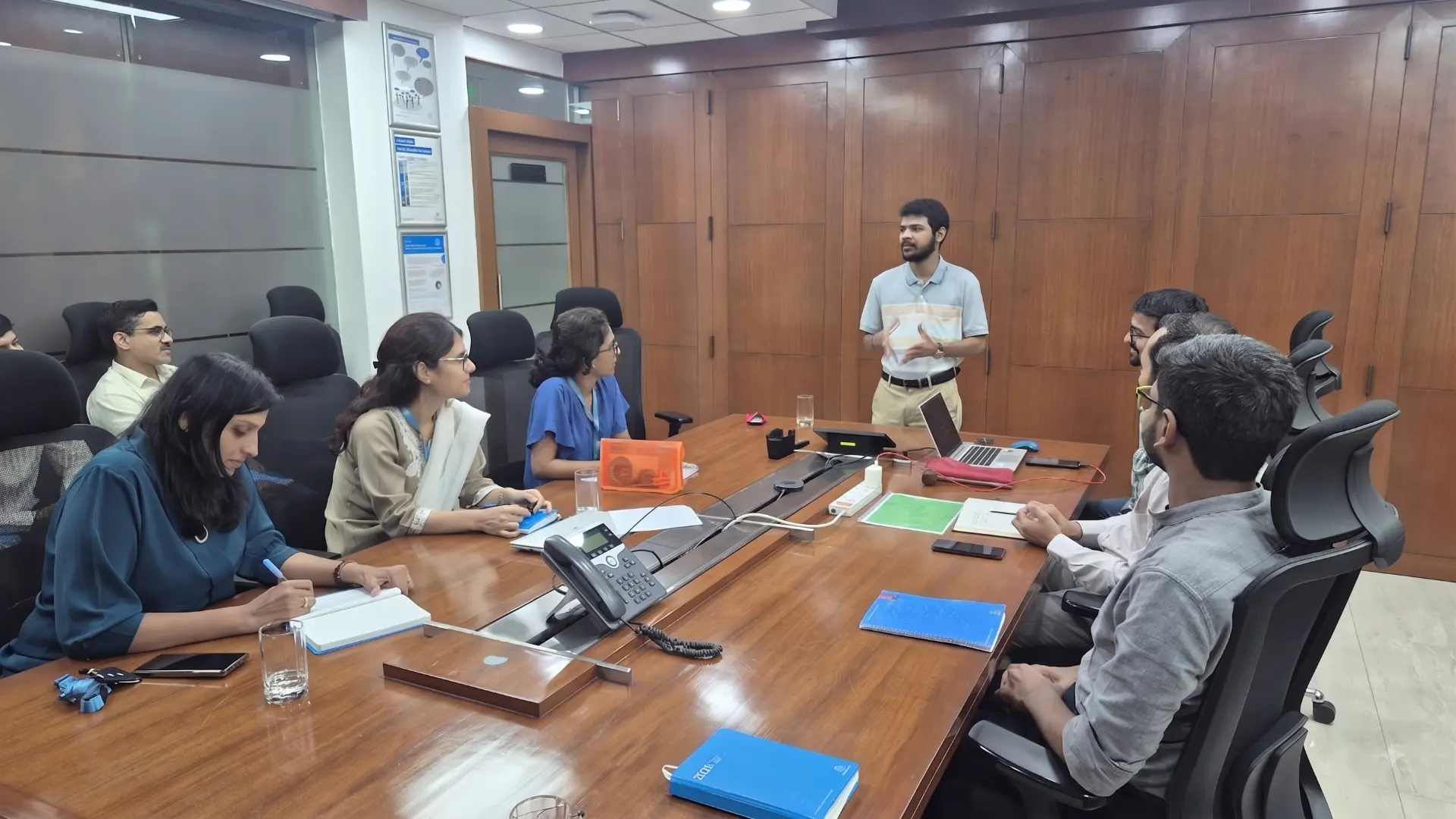 Coach facilitating a leadership discussion in a boardroom